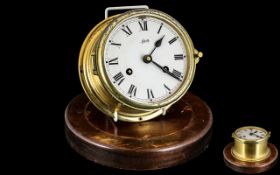 Original Brass Ships Clock, wind-up clock on wooden base, lacking glass; 7 inches (17.5cms) in