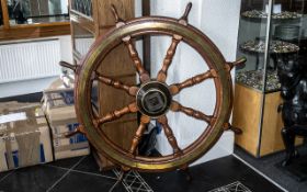A Extra Large Teak Antique Ship Wheel with brass mounts of typical form. Diameter 53 inches.