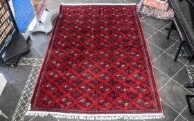 A Genuine Excellent Quality Persian Turkmen Carpet/Rug decorated in a Bukhari design on red ground.