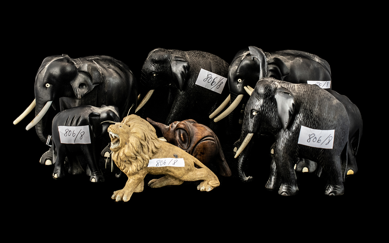 Group of Seven Ebony Elephants with tusks, plus a pottery lion figure (8)