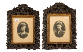 A Pair of Antique Carved Asian Picture Frames. The frames are heavily carved, depicting figures,