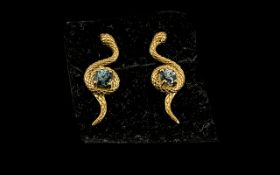 Blue Zircon 'Snake' Earrings, two round cut natural blue zircons, each set to the centre of a coil