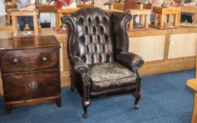 A Brown Leather Button Back Wing Chair. In Need of Re-Staining, Frame In Overall Good Condition.