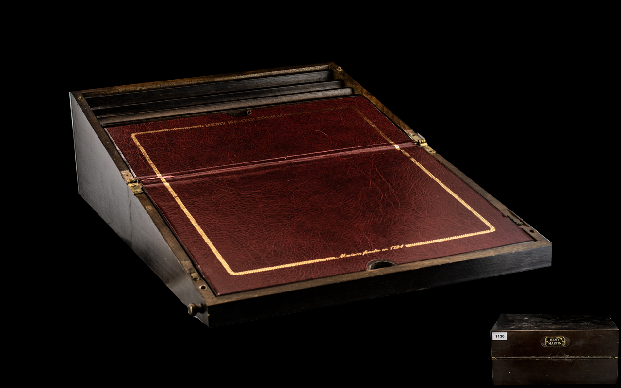 A Remy Martin interest - Mahogany finished writing slope of typical form with red leather tooled