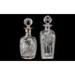 Two Cut Glass Decanters, one with a silver topped collar, and wheel cut decoration,
