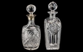 Two Cut Glass Decanters, one with a silver topped collar, and wheel cut decoration,