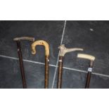 A Collection of Four Walking Canes one with a horn handle,