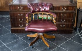 An Oxblood Leather Captain's Chair of typical form with button back. Height 32", widest point 24".