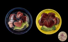 Two Moorcroft Dishes, one 5.5" diameter in dark blue with pink Hibiscus, chipped; and a 4.