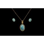 A 14ct Gold Pendant set with a turquoise coloured cabochon stone.