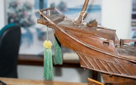 Model Boat of A Pirate Ship made out of wood and on a plinth. Chinese engravings to the rear.