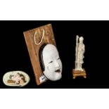 A Small Japanese Ivory Figure 7" high with a Japanese erotic decorated face mask mounted on a wood