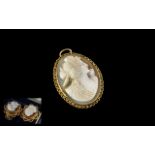 Cameo Pendant with delicate gold fretwork edging, marked 9 ct.