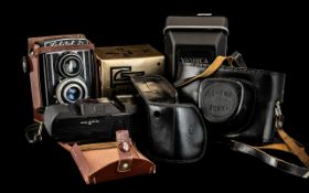 Five Assorted Vintage Cameras with accessories and booklets on camera settings,
