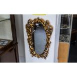 Ornate Gold Painted Mirror, oval shaped with scroll shapes and two winged figures,