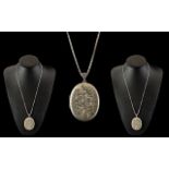 A Vintage Large and Impressive Sterling Silver Oval Shaped Hinged Locket with Chased Decoration to