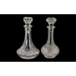 Two Cut Glass Decanters, both with decorative stoppers, each measuring 25 cm tall.
