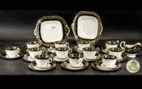 A Thirty Eight (38) Piece Aynsley Tea Set decorated with a black band and highlighted in gilt work.