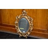 Fine Quality Florentine Carved Giltwood Mirror of oval shape, with flowing, sinuous foliage; c1900,
