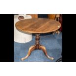 A George III Oak Tilt Top Table, circular top, raised on turned supports, cabriole legs.