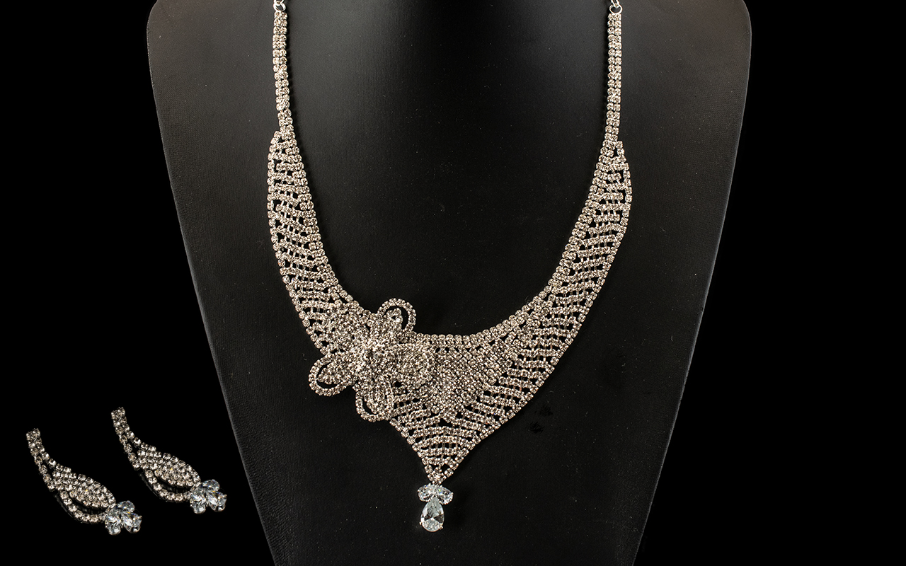 White Crystal Asymmetric Necklace and Matching Earrings, a fully crystal encrusted bib necklace with