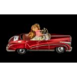 Large Vintage Rolls Royce Type Tinplate Car in red livery, with a loving couple in the driving seat,