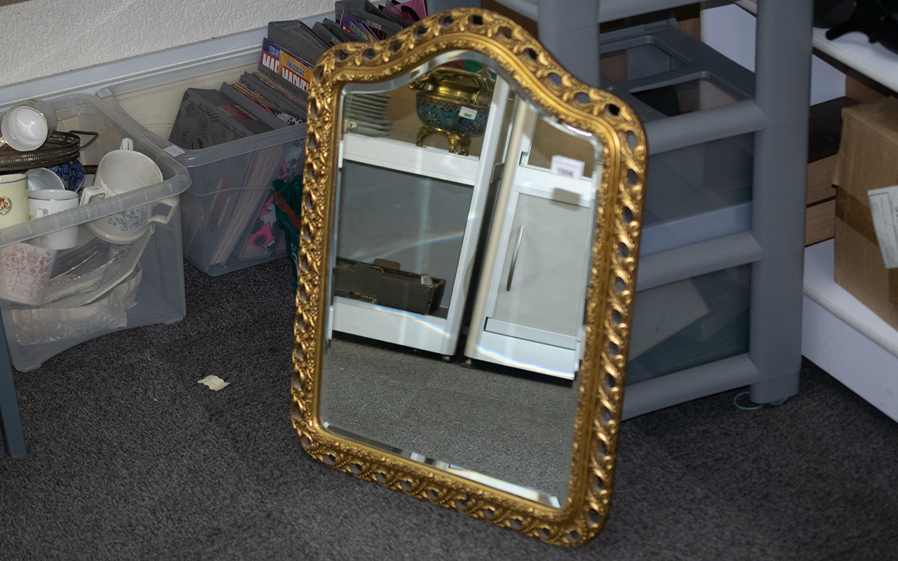 Shaped Gilt Framed Mirror, with a bevelled edge, in the Florentine style. Measures 25" x 19".