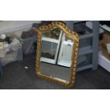 Shaped Gilt Framed Mirror, with a bevelled edge, in the Florentine style. Measures 25" x 19".