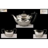 Small Silver Three Piece Harlequin Bachelor Tea Set, with embossed, fluted bodies and ebony handles;