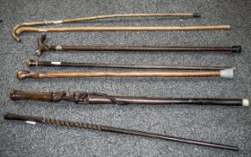 Seven Various Walking Sticks comprising two carved African figural sticks, a carved,