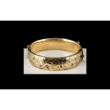 A 9ct Gold Metal Core Hinged Bangle, chaste floral decoration to front,