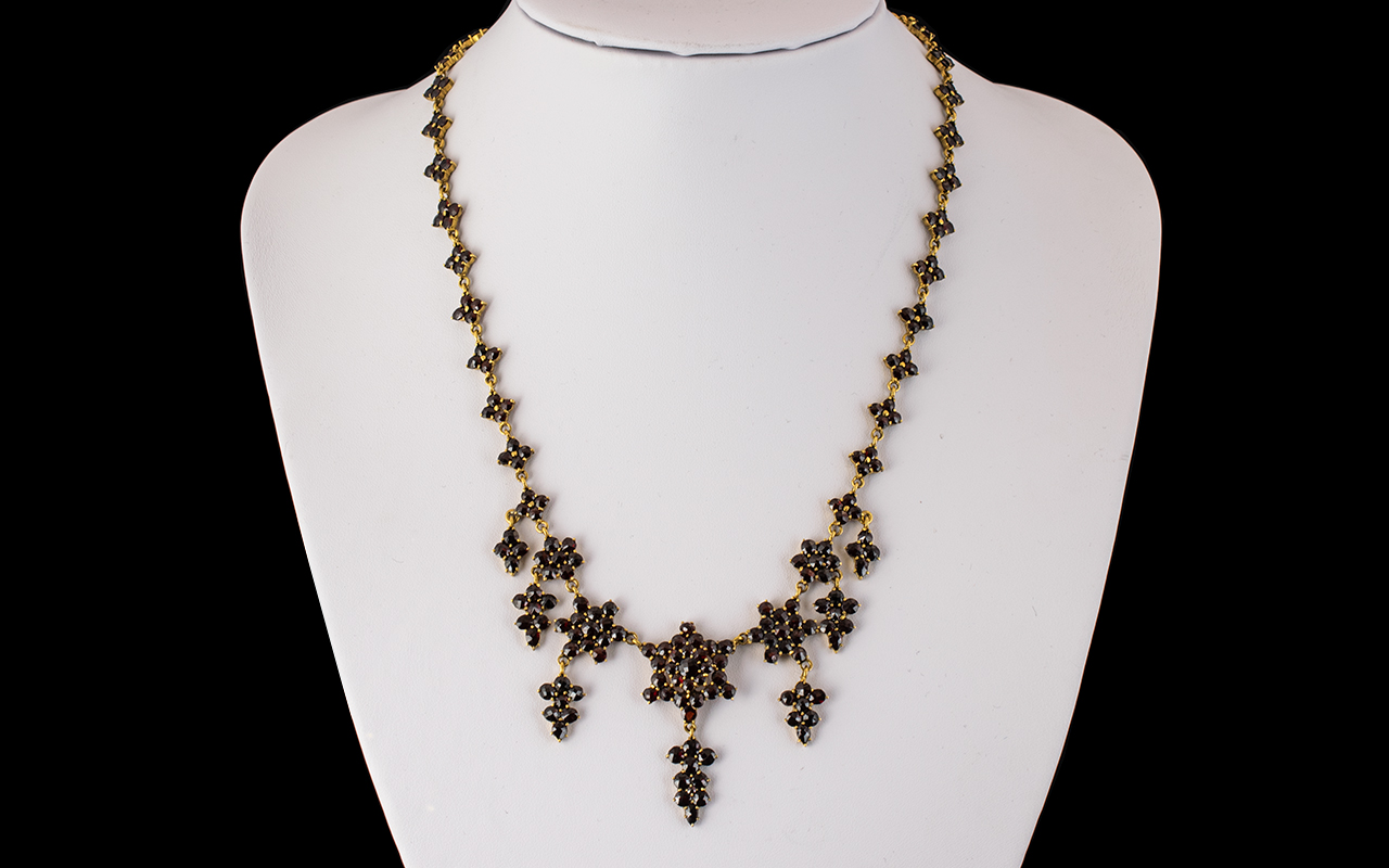 An Antique 19th Century Garnet Fringe Necklace, set in unmarked 9ct gold, of floral design with
