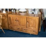 An Ercol Sideboard, Three Cupboards above two drawers, interior drawer for cutlery,