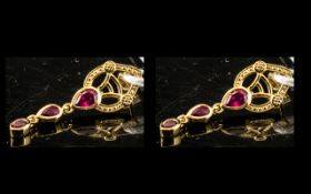 Ruby Triple Drop Earrings, each earring comprising three graduated pear cut rubies, bezel set and