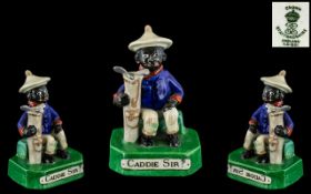 Cricket Interest A Crown Staffordshire Figure of a seated black boy with golf bag,