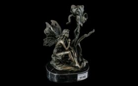 A Bronze Figural Candle Holder, in the form of a fairy and a water lilly.