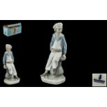 Lladro Figure of Boy on a Capstan, holding a model boat. Approx 9.5" tall, in original box.