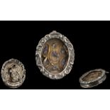 An Italian Silver Relic housed in an oval frame, glazed front,