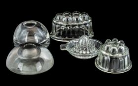 Pair of Large Victorian Glass Inkwells, together with three moulded jelly moulds.