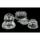 Pair of Large Victorian Glass Inkwells, together with three moulded jelly moulds.