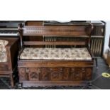 Mid 20th Century Monks Bench of typical form with hinged seat and carved panelled front,