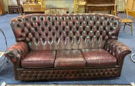 Burgundy Coloured Leather Winged Button Back Three Seater Settee with a matching armchair.