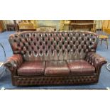 Burgundy Coloured Leather Winged Button Back Three Seater Settee with a matching armchair.