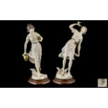 A Pair of Italian Female Capodimonte Figures raised on wooden bases and measuring 17 inches in