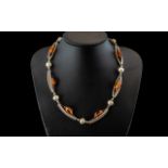 A Modern Design Silver and Amber Necklace - tubular and bauble links with Amber spacers.