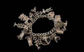 A Vintage Sterling Silver Charm Bracelet - Loaded with 15 Good Quality Silver Charms.