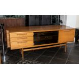 A Mid Century Designer Teak Sideboard, with a glass centre covered doors,