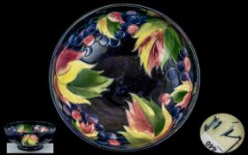 William Moorcroft Signed Tube lined Footed Bowl ' Leaf's and Berries ' Design on Blue Ground. c.