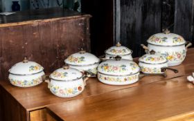 Set of Enamel Pans with Lids in cream with floral decoration, comprising four saucepans, a teapot,