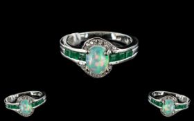 Opal and Emerald Ring, size O, an oval cabochon cut opal, with a good spectrum of colour play,